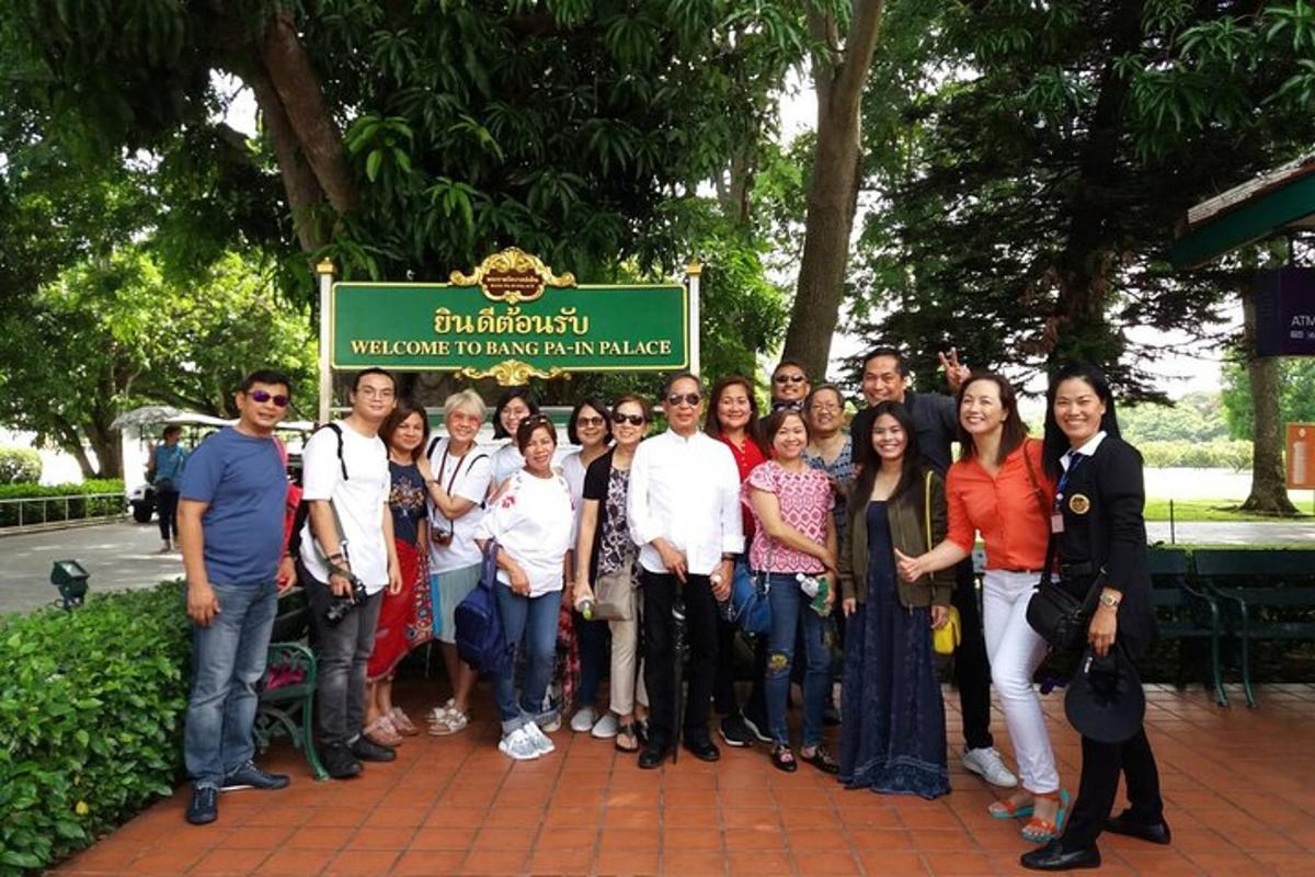 Un grupo de personas posando para una foto delante de un cartel.
