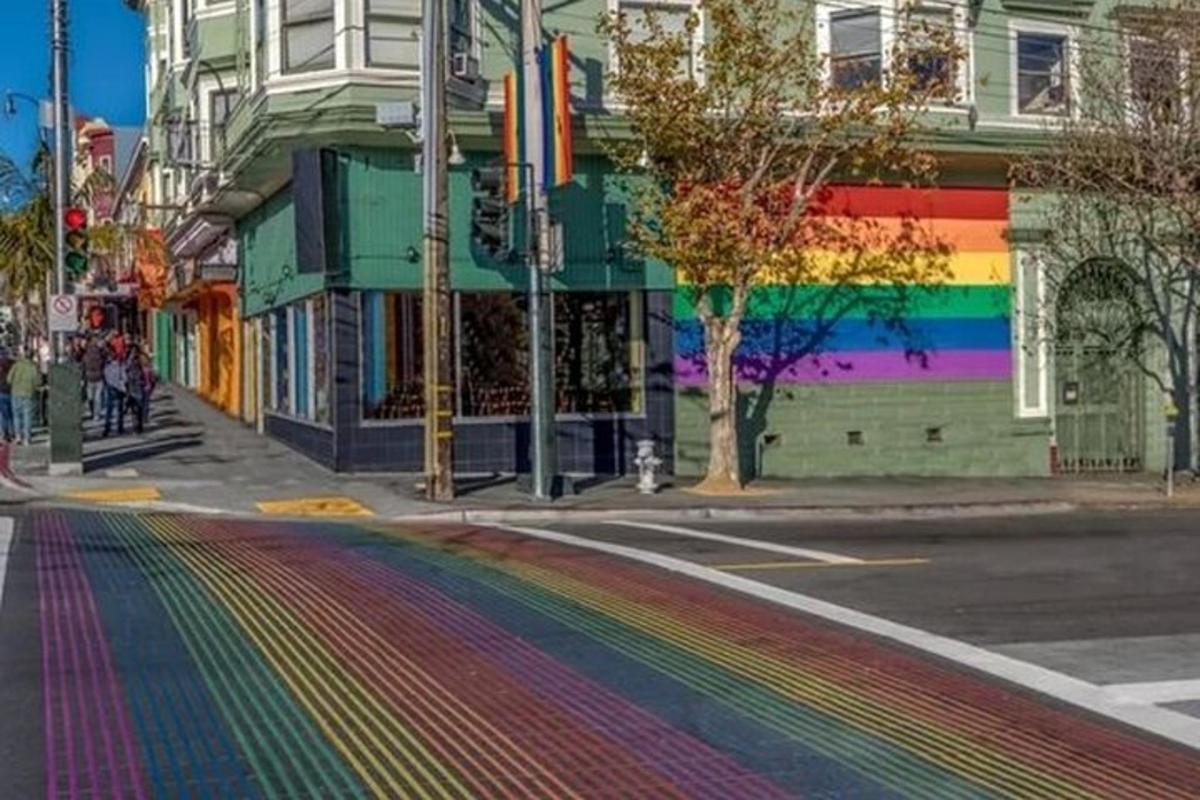 una calle con un arcoíris pintado en el costado de un edificio