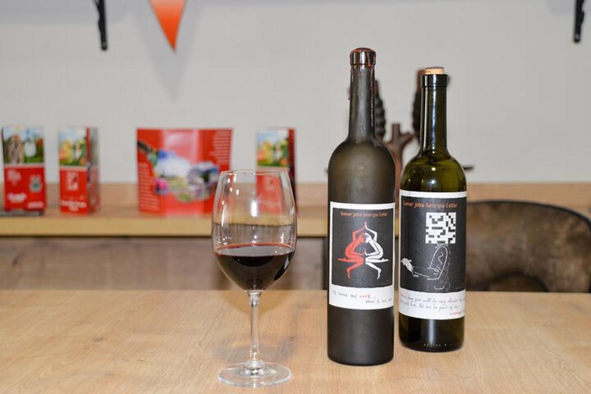 duas garrafas de vinho e uma taça sobre uma mesa