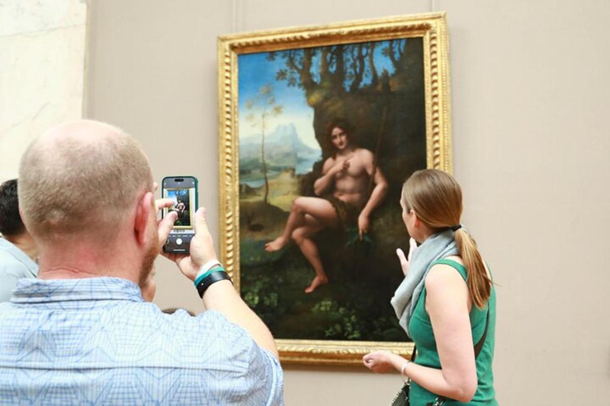 a man taking a picture of a woman in front of a painting