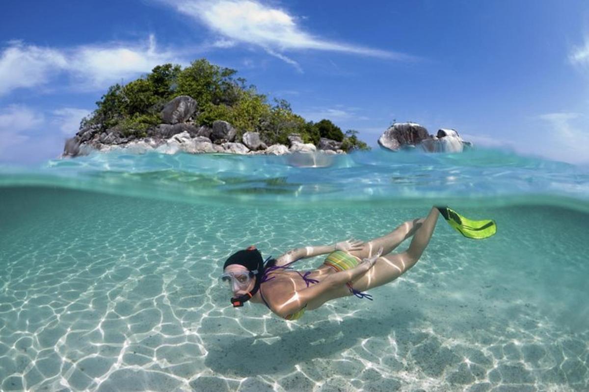 seorang wanita berbaring di dalam air di hadapan sebuah pulau