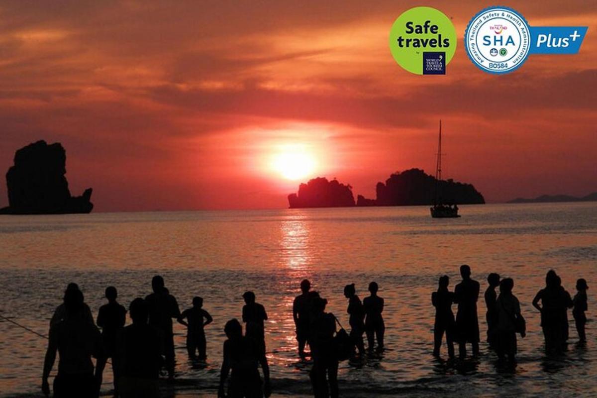 sekumpulan orang berdiri di dalam air pada waktu matahari terbenam