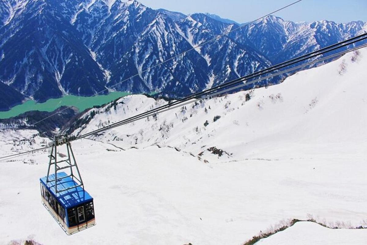a ski lift flying over a snow covered mountain