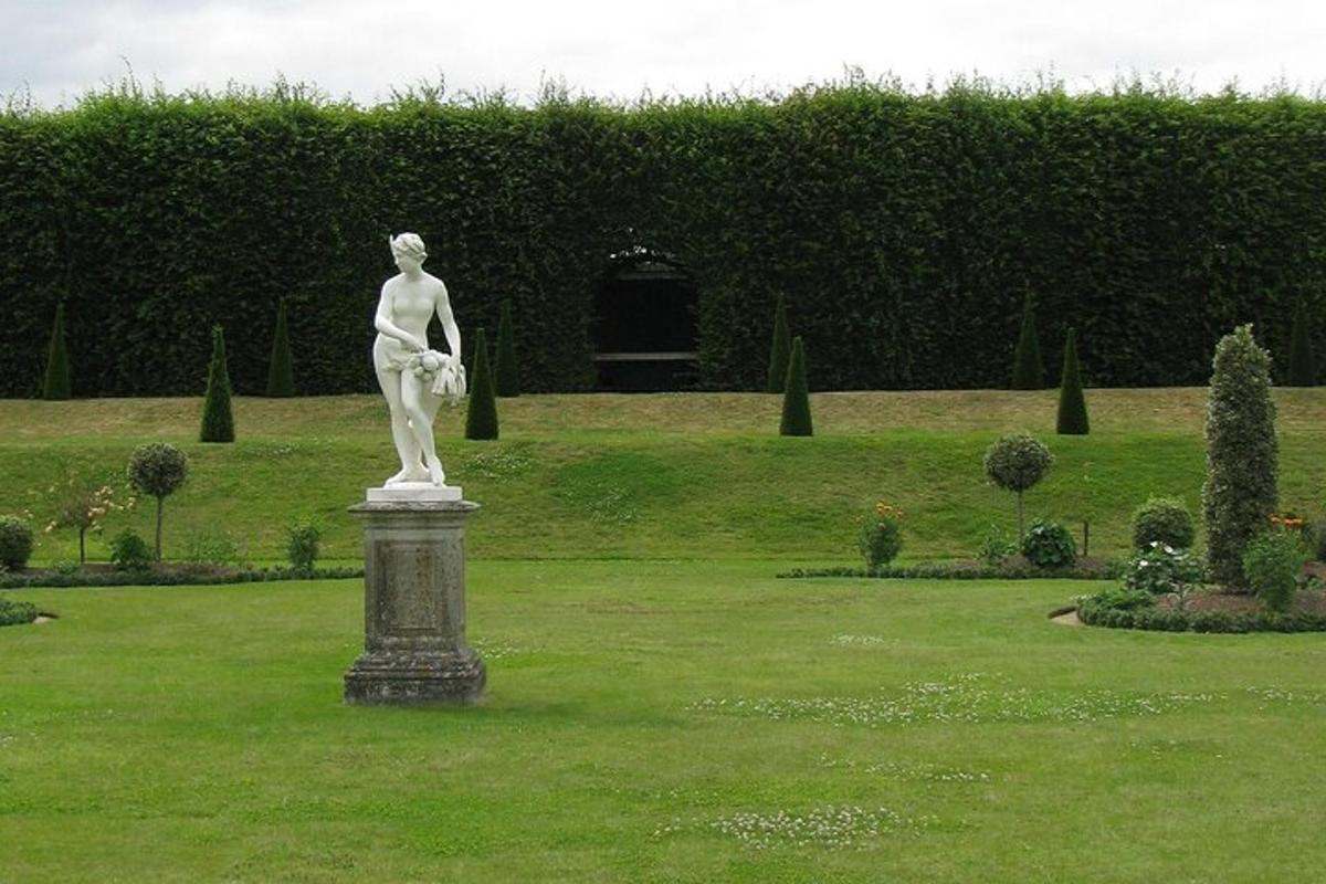 una estatua de una mujer en un pedestal en un parque