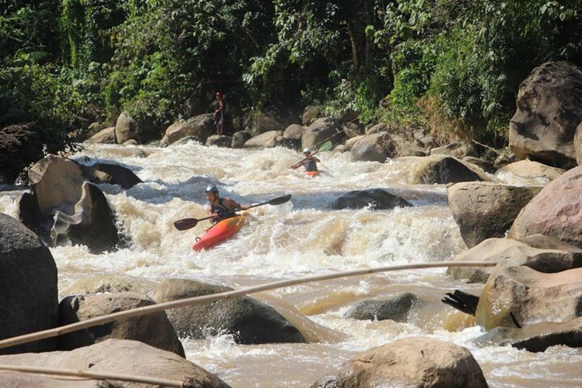 un gruppo di persone che fa kayak su un fiume con rocce