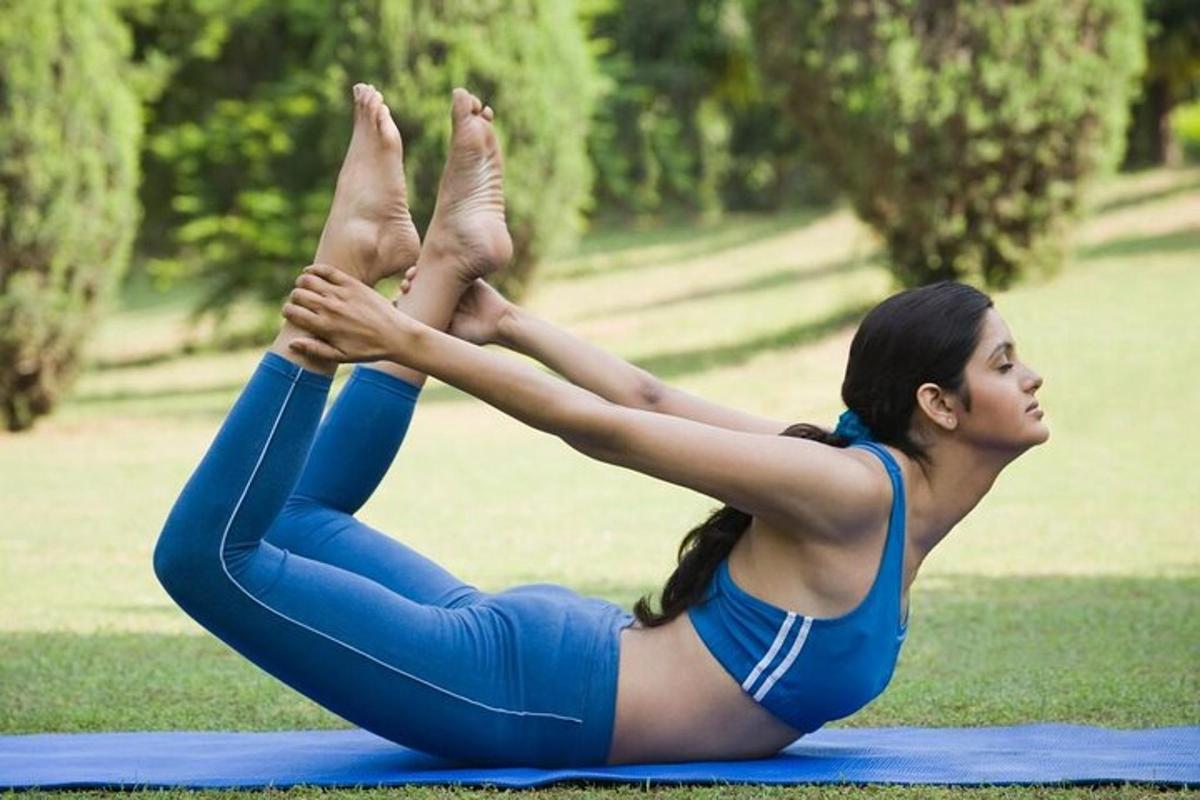 a woman doing a yoga pose in the grass