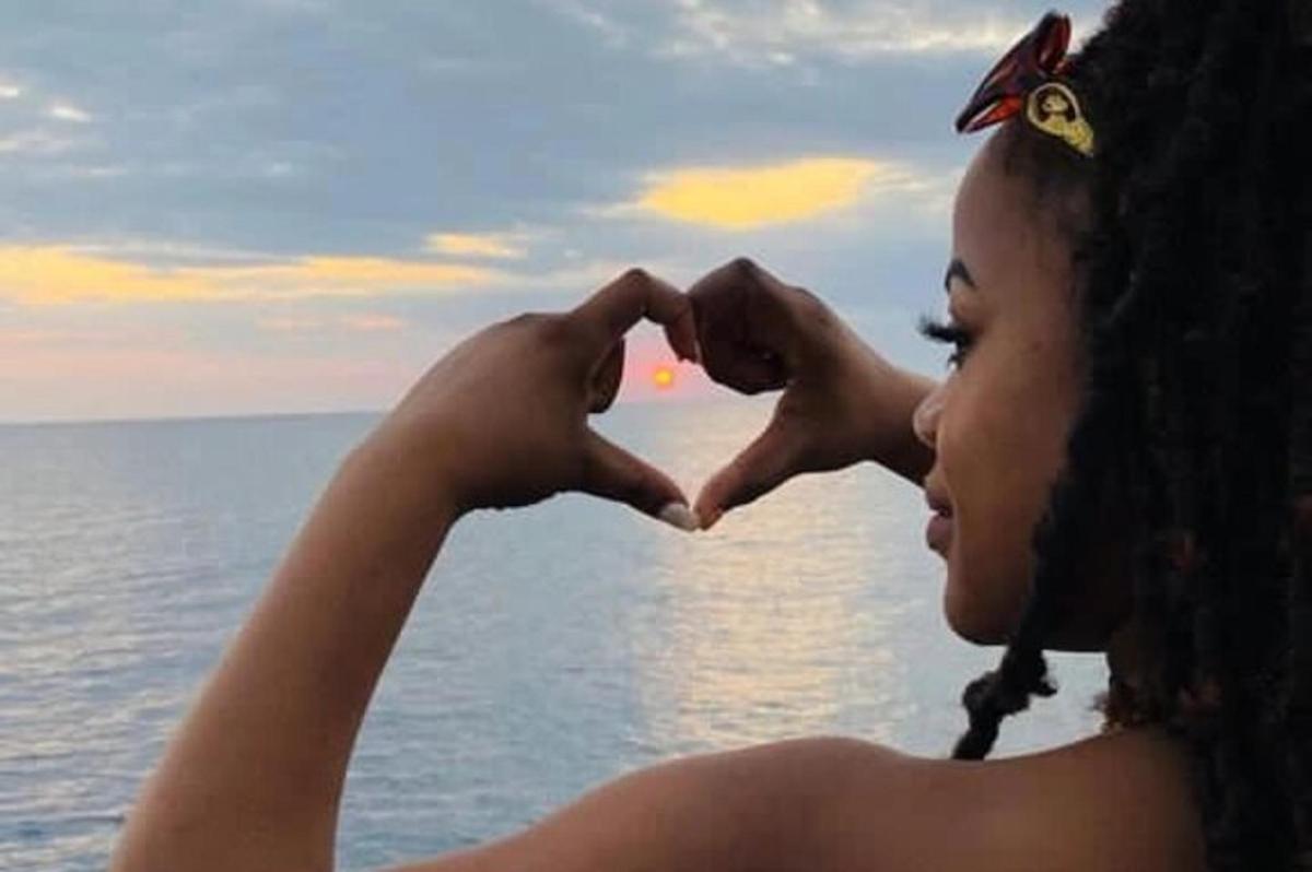Una mujer haciendo un signo de corazón con sus manos.