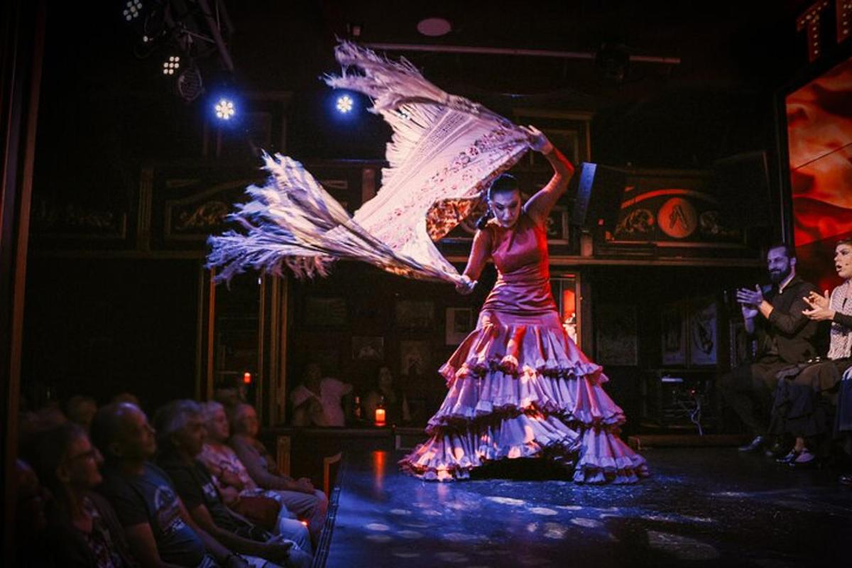 a woman in a dress on a stage with a fan