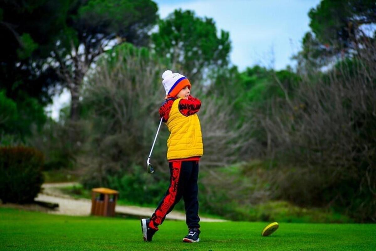 Mladý chlapec hraje golf v parku