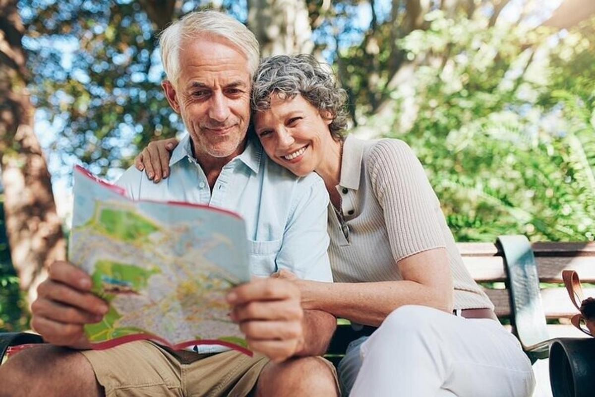 un uomo e una donna seduti su una panchina che guardano una mappa