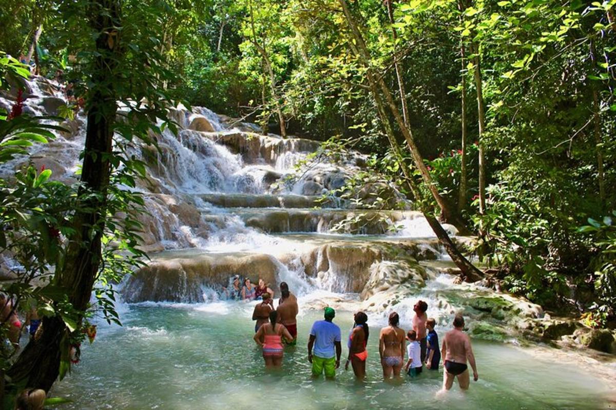 un gruppo di persone in piedi nell'acqua vicino a una cascata