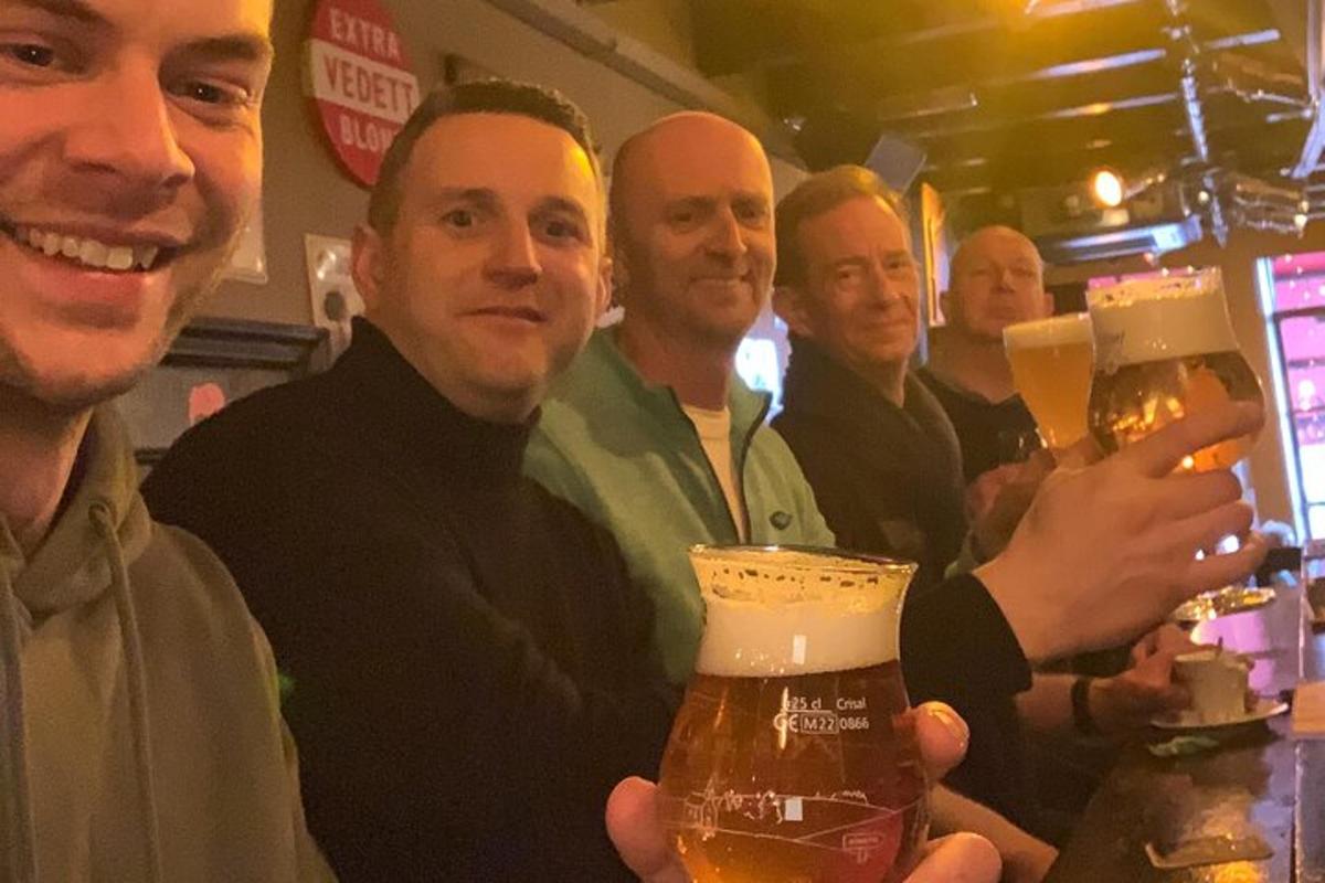 un grup de bărbați care țin în mână halbe de bere