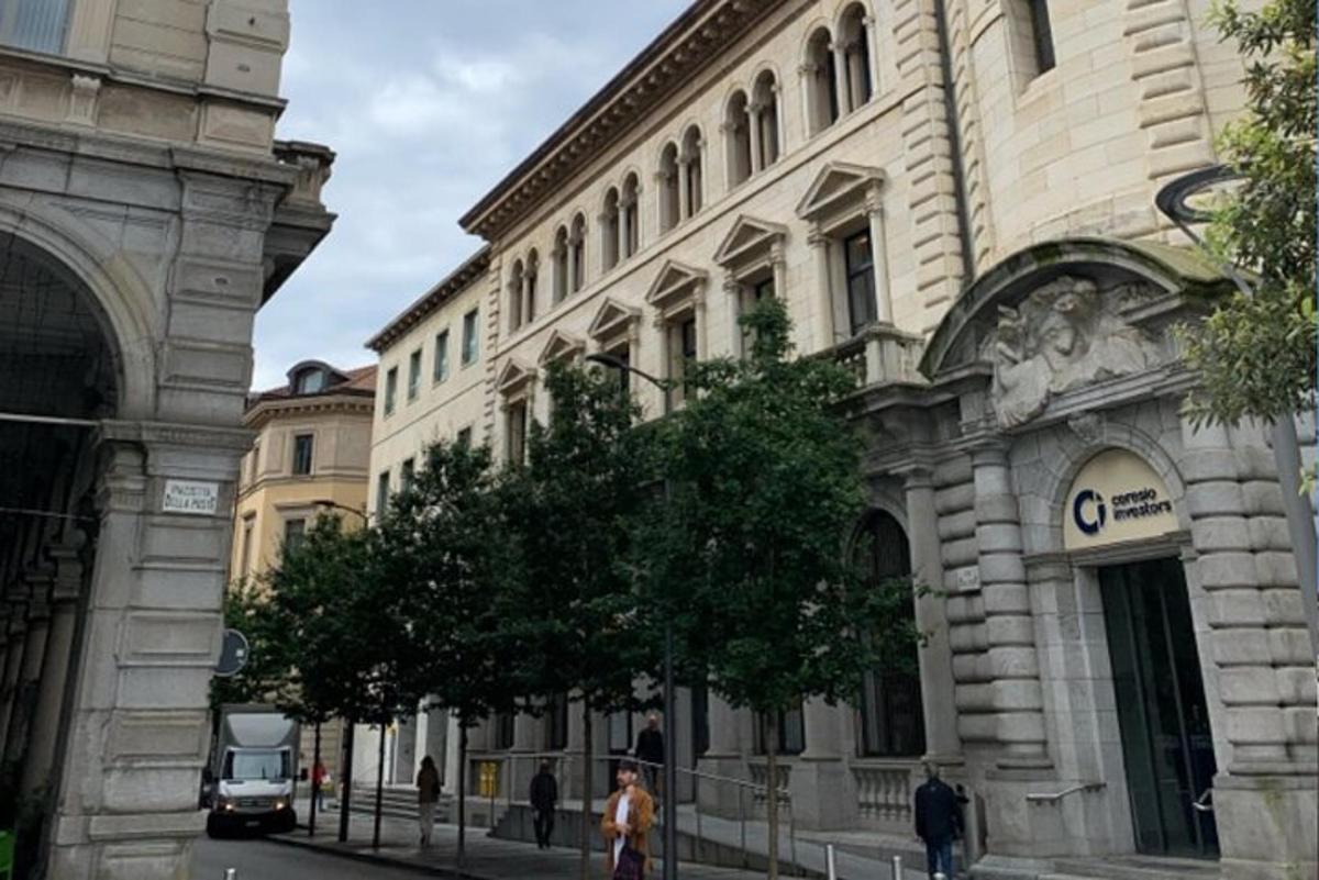 un home caminant per un carrer davant d'un edifici