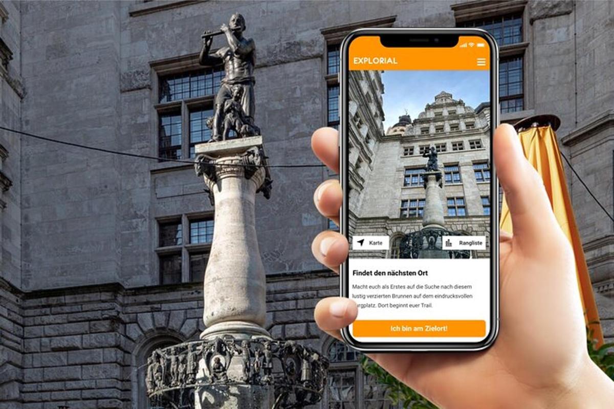 una persona sostenint un telèfon mòbil davant d'una estàtua