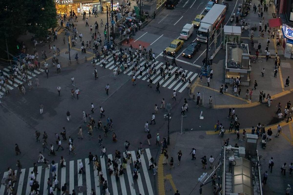 una folla di persone che attraversa una strada in una città