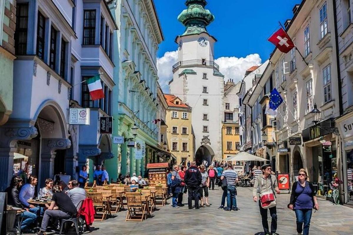 група људи која хода улицом са сат-кулом