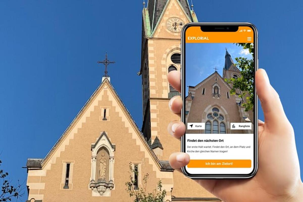 o persoană care ține un telefon mobil în fața unei biserici