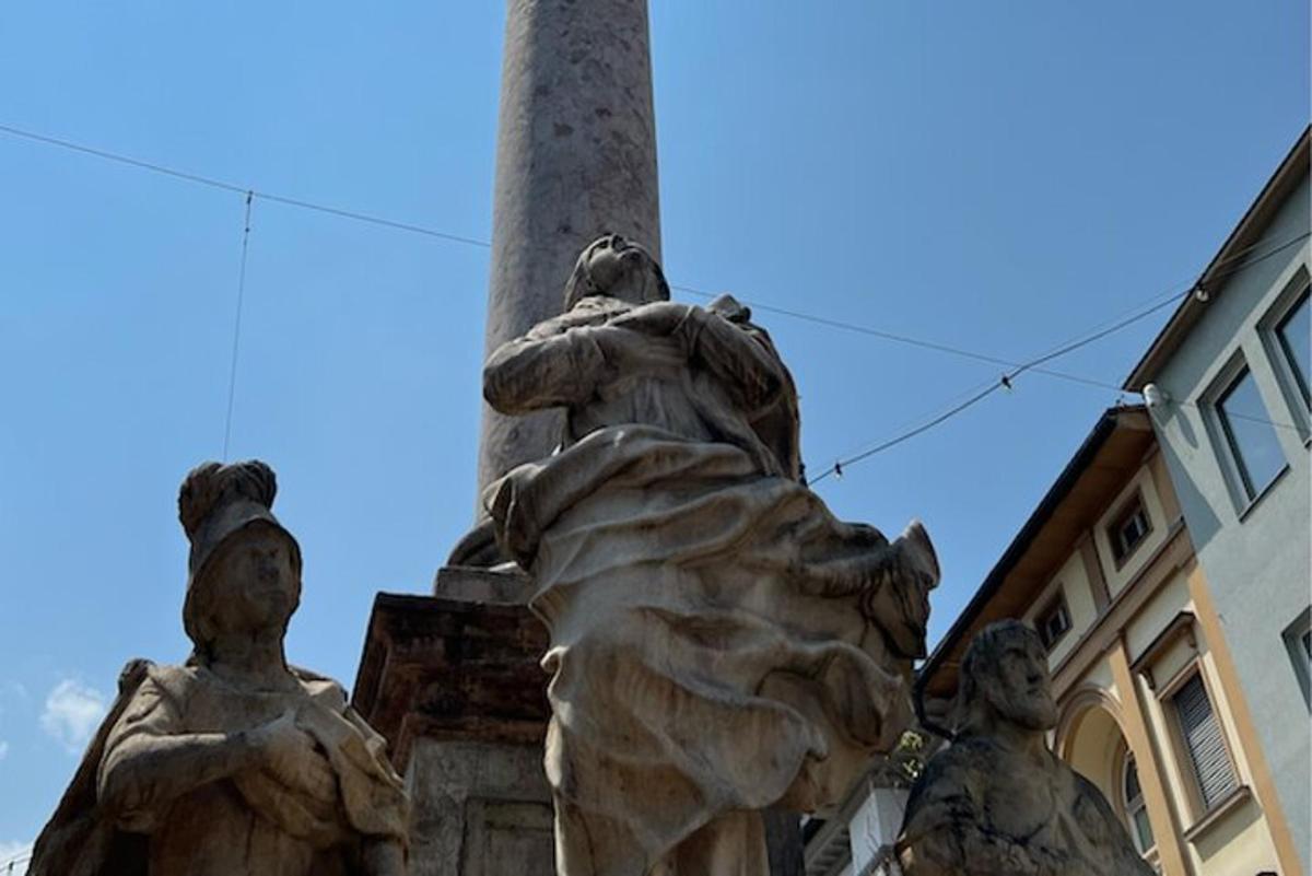 o statuie în fața unui stâlp