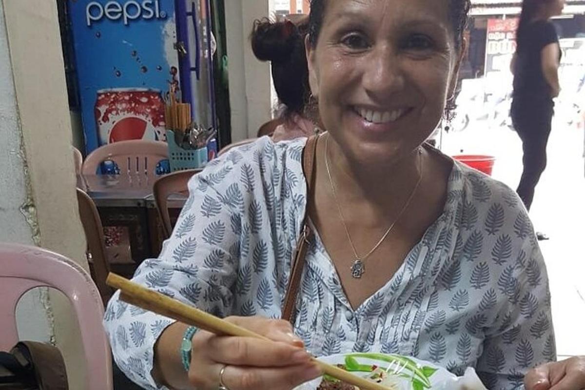 seorang wanita memegang pinggan makanan dengan penyepit