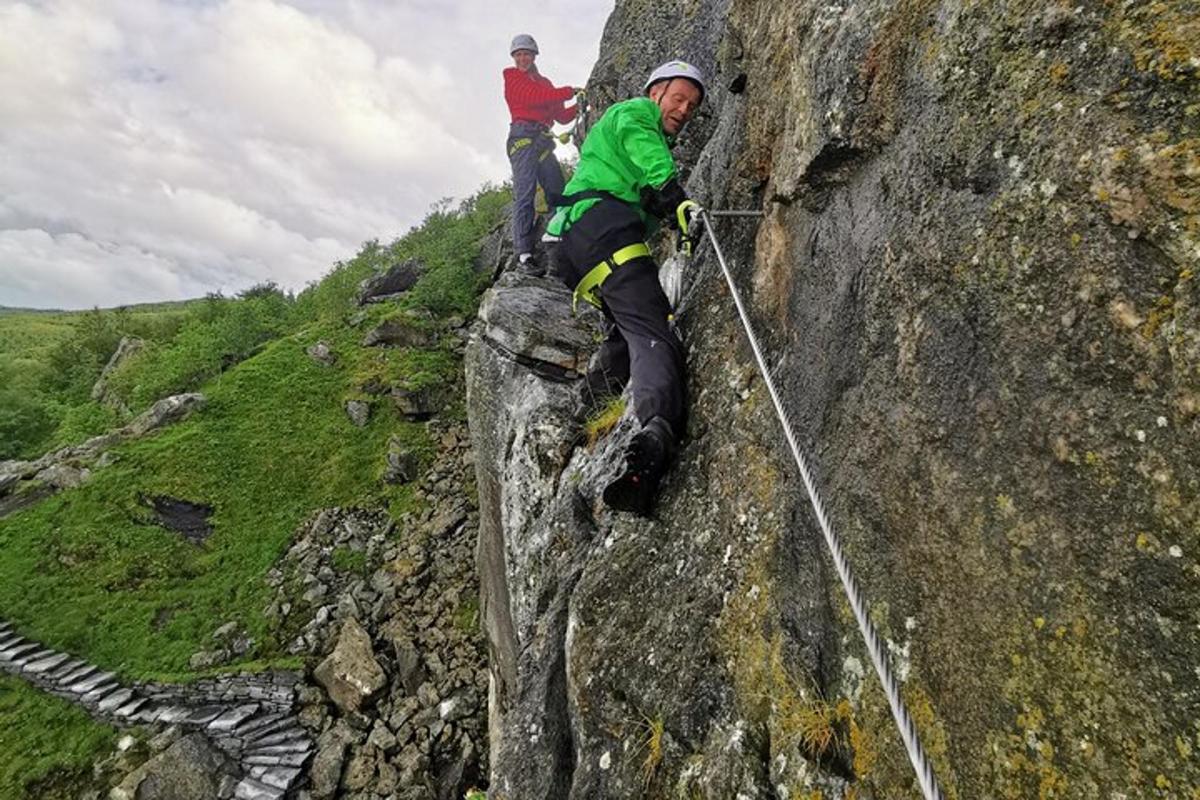 two people on a rock wall on a mountain