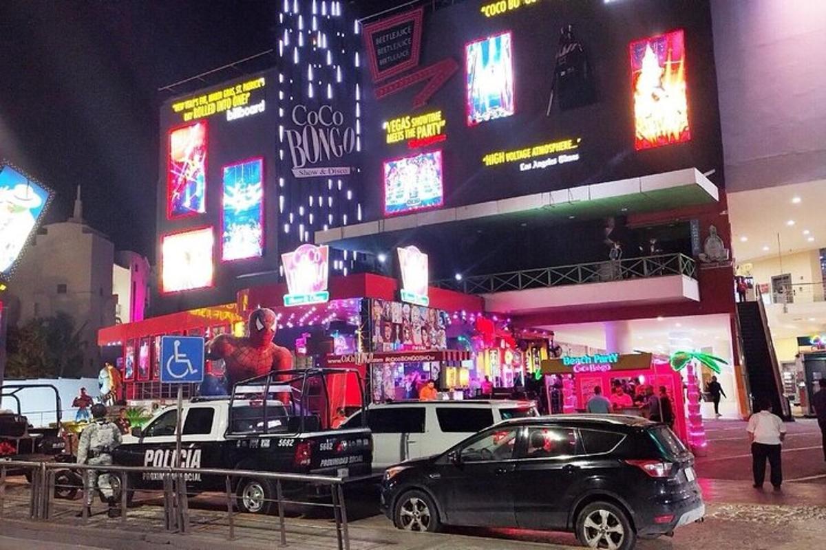zwei Autos parkten vor einem Gebäude mit Neonschildern