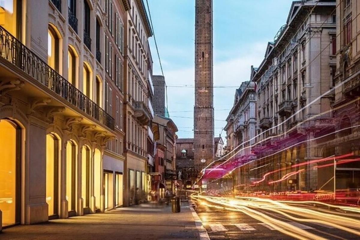 una strada cittadina con un'alta torre in lontananza