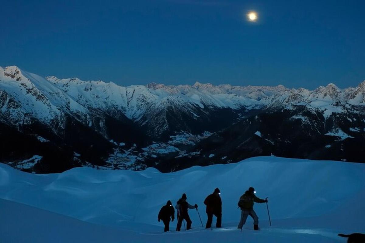 Un grupo de personas de pie en la cima de una montaña cubierta de nieve.