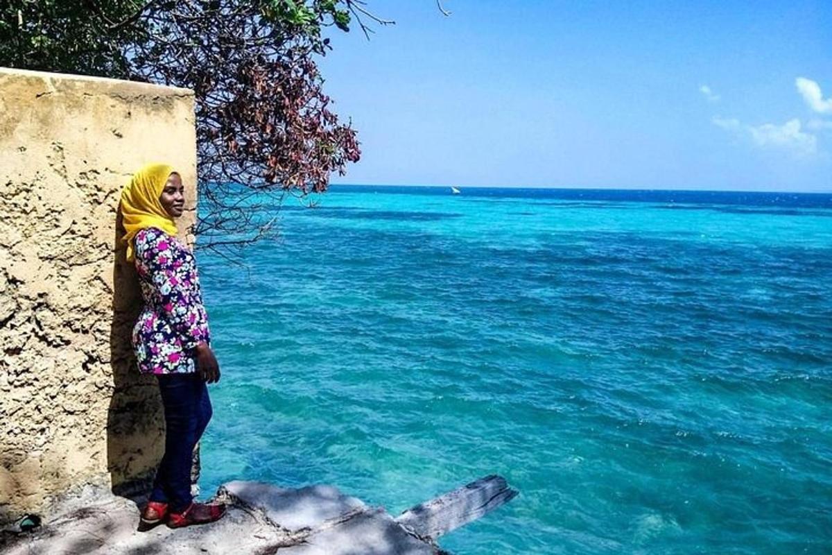 žena stojící vedle zdi na břehu oceánu