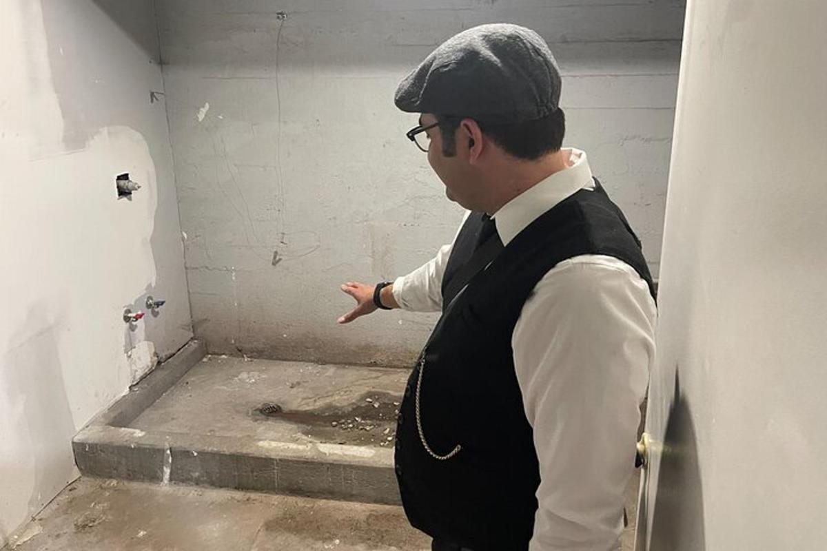 a man standing in a room pointing at a wall
