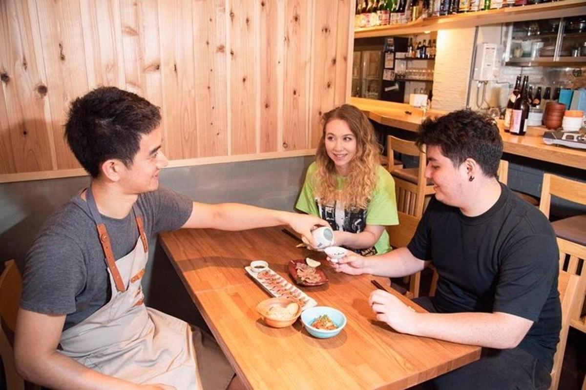 tři lidé sedící u stolu v restauraci