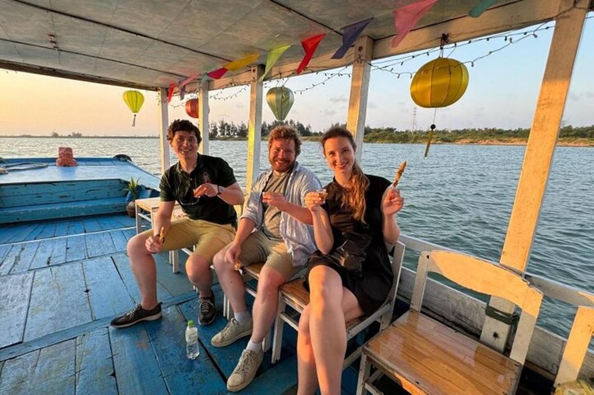 tři lidé sedící na zadní straně lodi