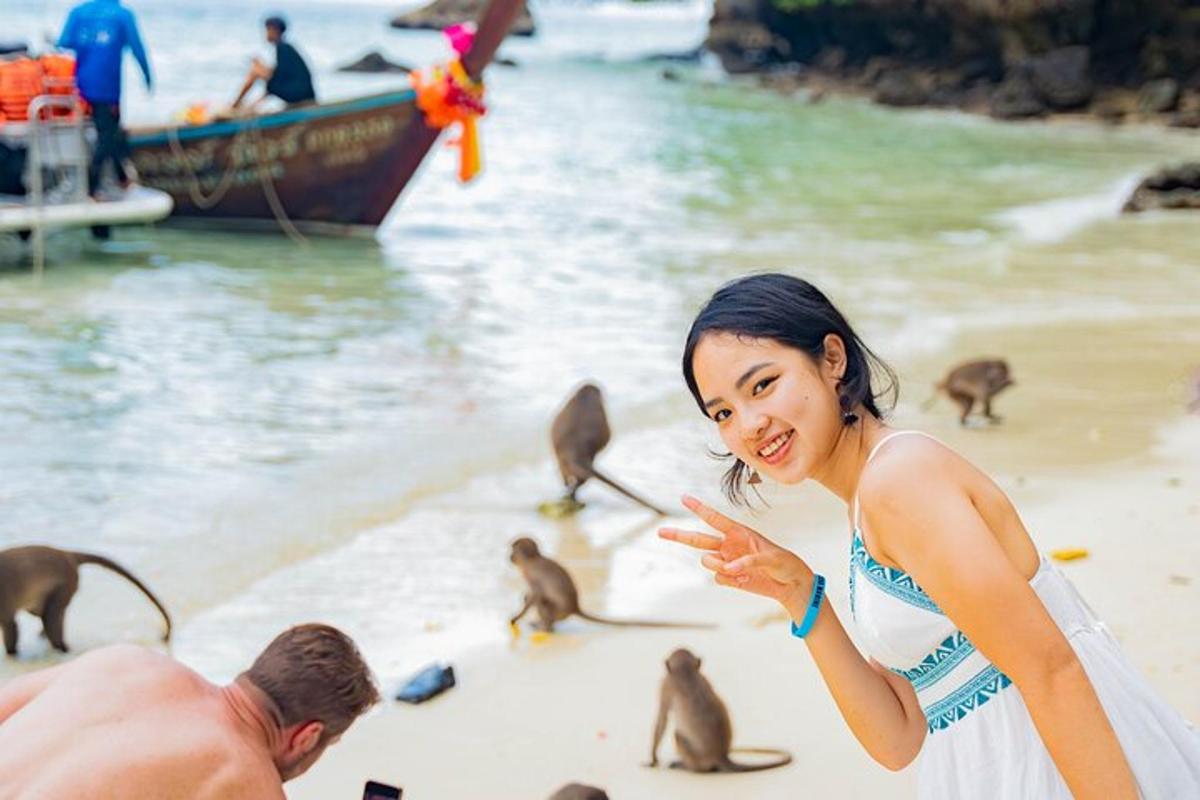 Una mujer parada en una playa con un grupo de monos.