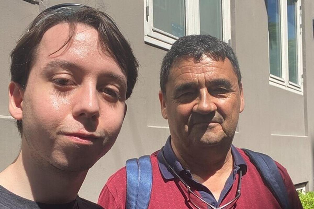 dois homens parados um ao lado do outro em frente a uma casa