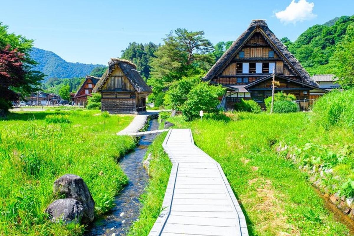 a walkway in front of a house and a river