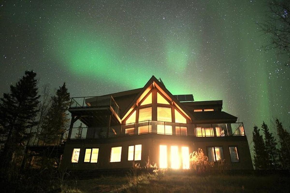 a house with the northern lights in the sky