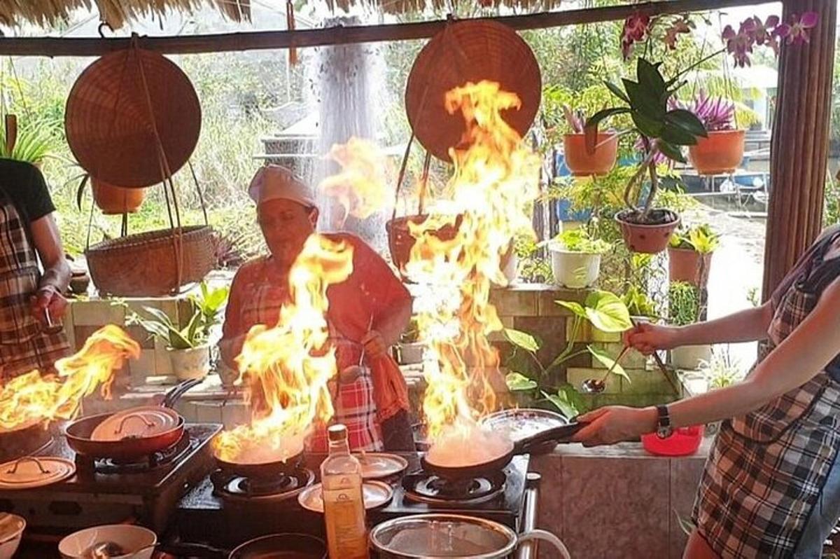 un uomo che cucina cibo su una stufa con il fuoco