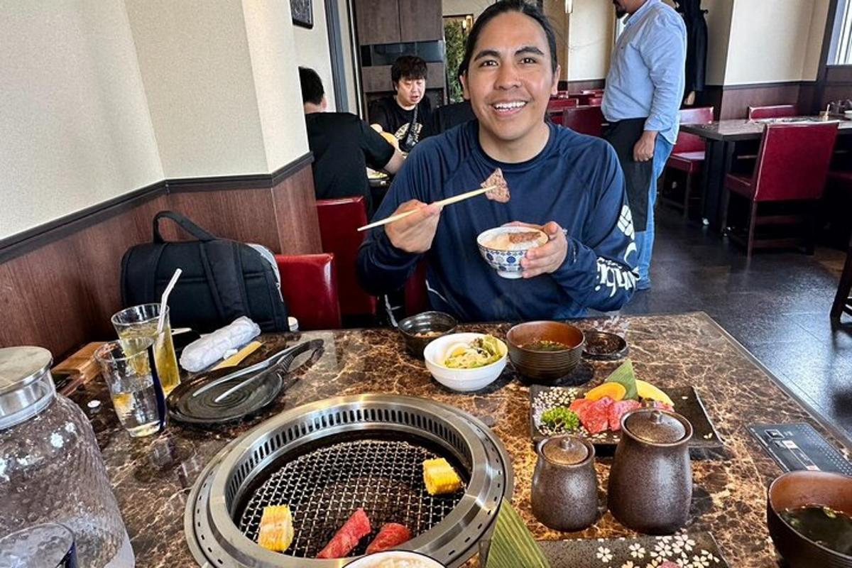 一位男士坐在桌边，手里拿着一碗食物