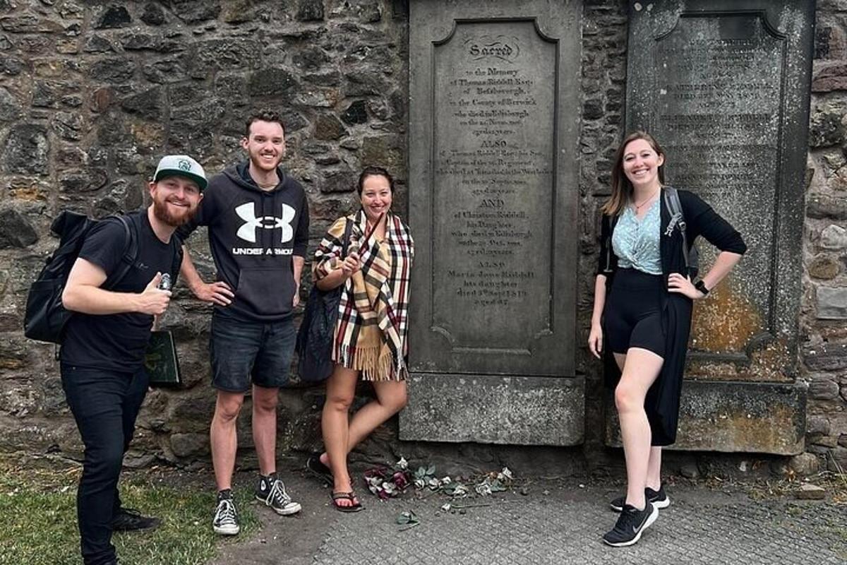 un grup de persones dempeus davant d'una tomba