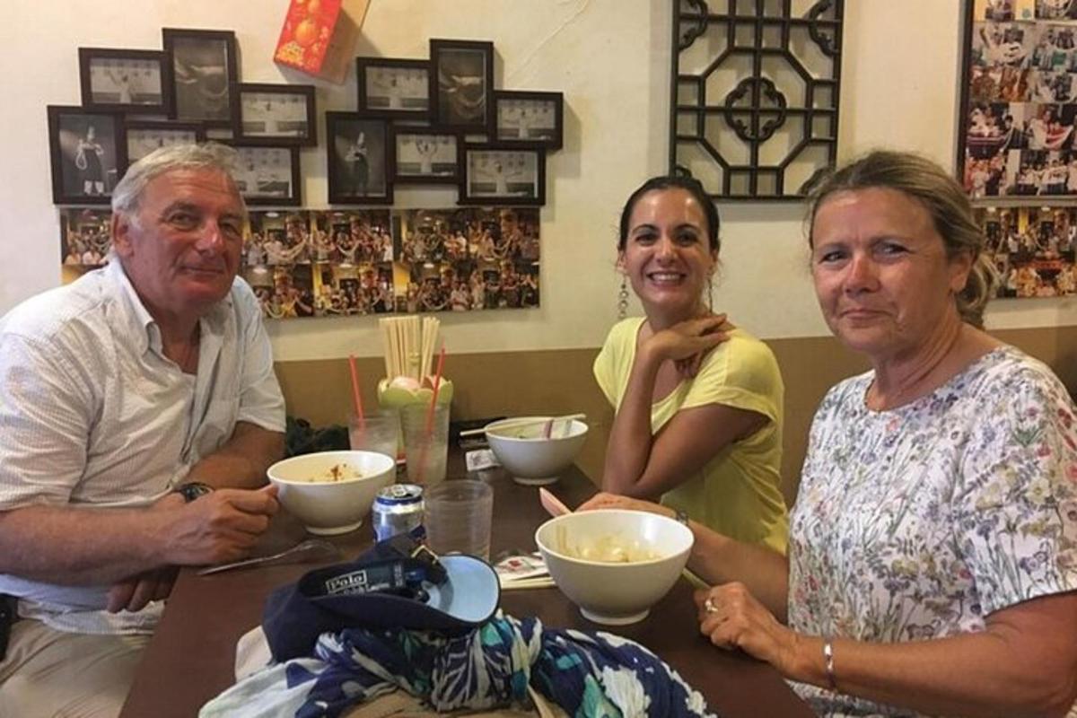 three people sitting at a table with bowls of food