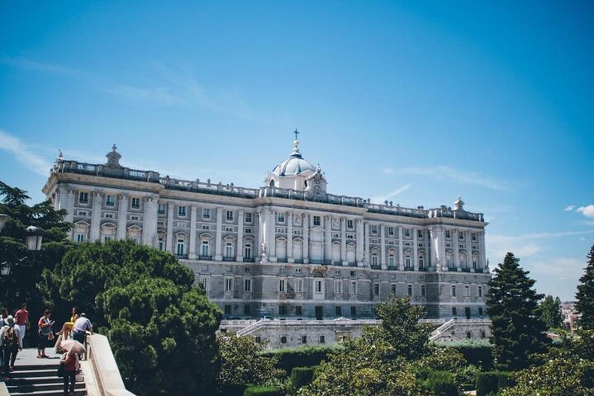 stór hvít bygging með fólki sem stendur fyrir framan hana