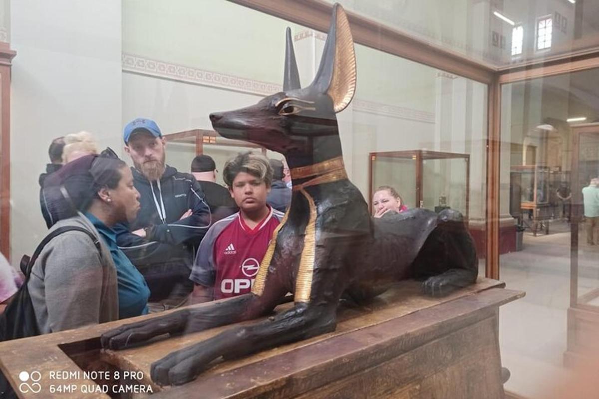 žmonių grupė, stovinti šalia triušio statulos