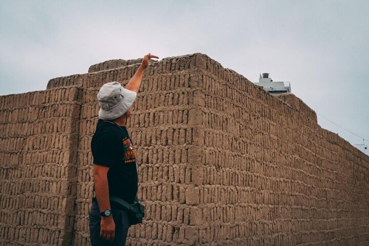 un hombre parado junto a una pared de ladrillos