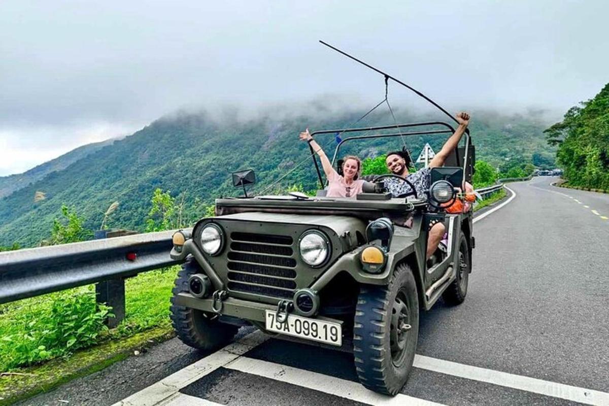 um homem e uma mulher em um jipe dirigindo por uma estrada