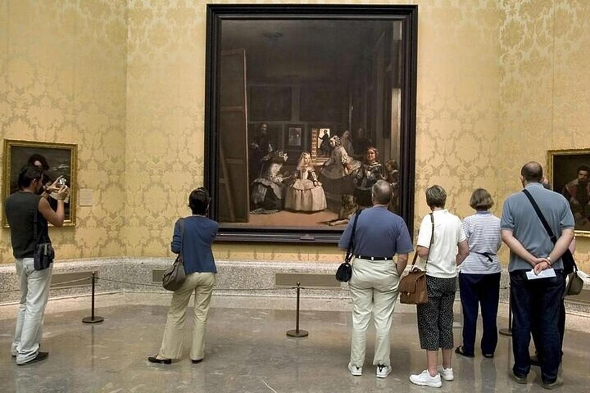 un gruppo di persone che guardano un dipinto in un museo