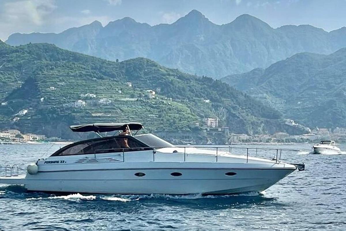 een witte boot op het water met bergen op de achtergrond