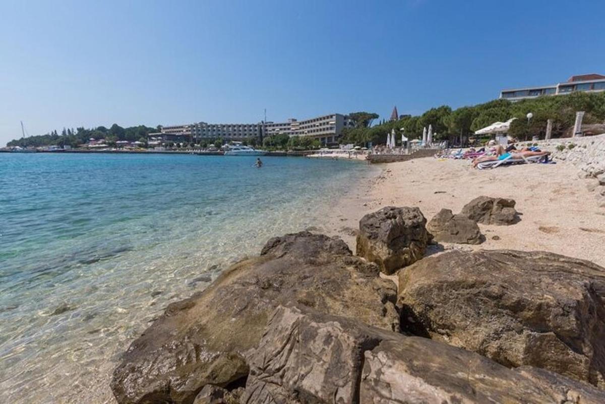 μια αμμώδης παραλία με βράχια στο νερό