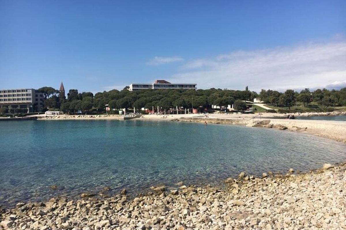 una spiaggia con una costa rocciosa con edifici sullo sfondo
