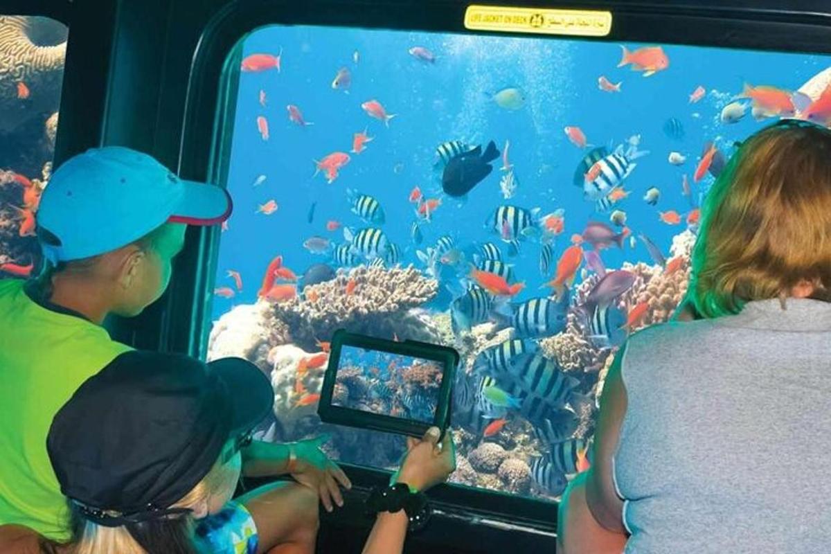 a group of people looking at fish in an aquarium