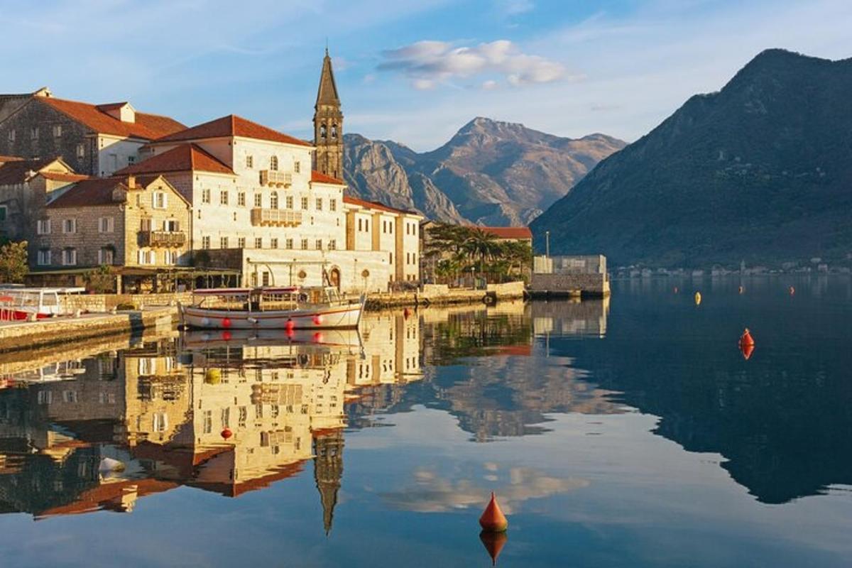 un edifici amb una torre de rellotge al costat d'una massa d'aigua