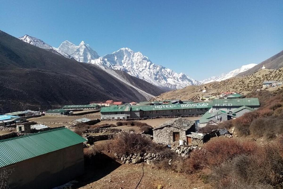 a train traveling through a mountain village with mountains in the background